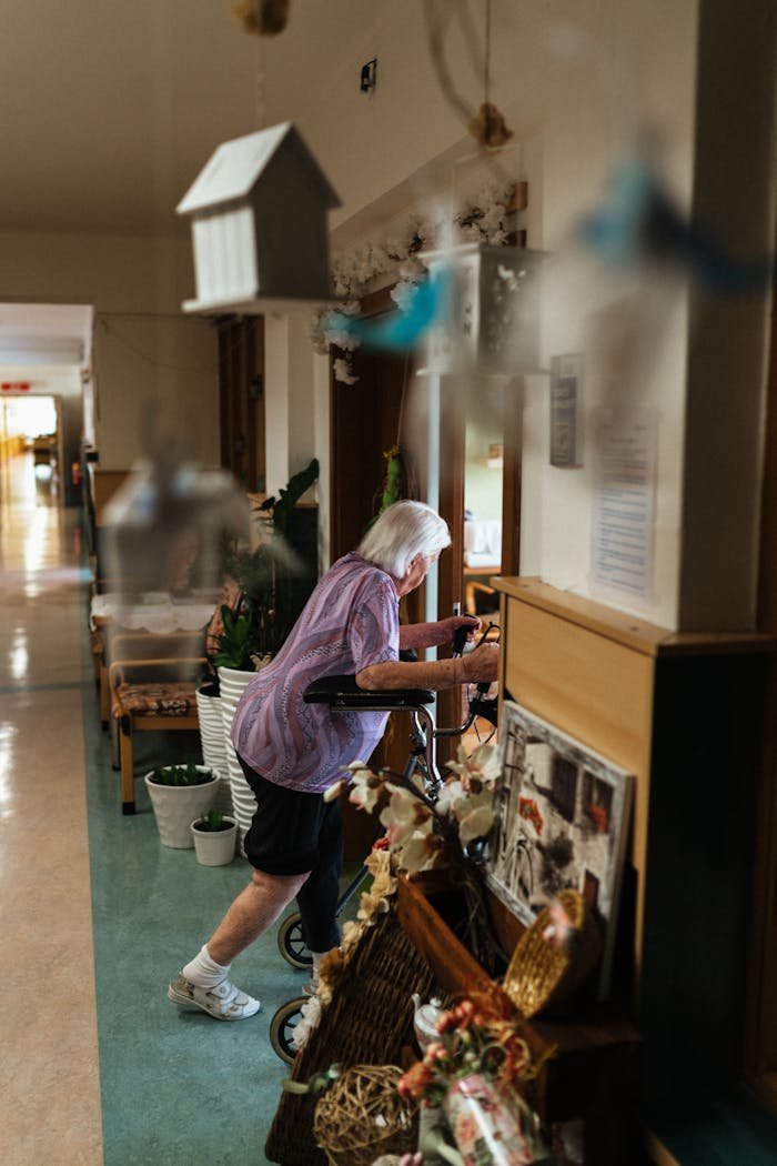 Elderly Woman With a Walking Frame in a Retirement Home Corridor